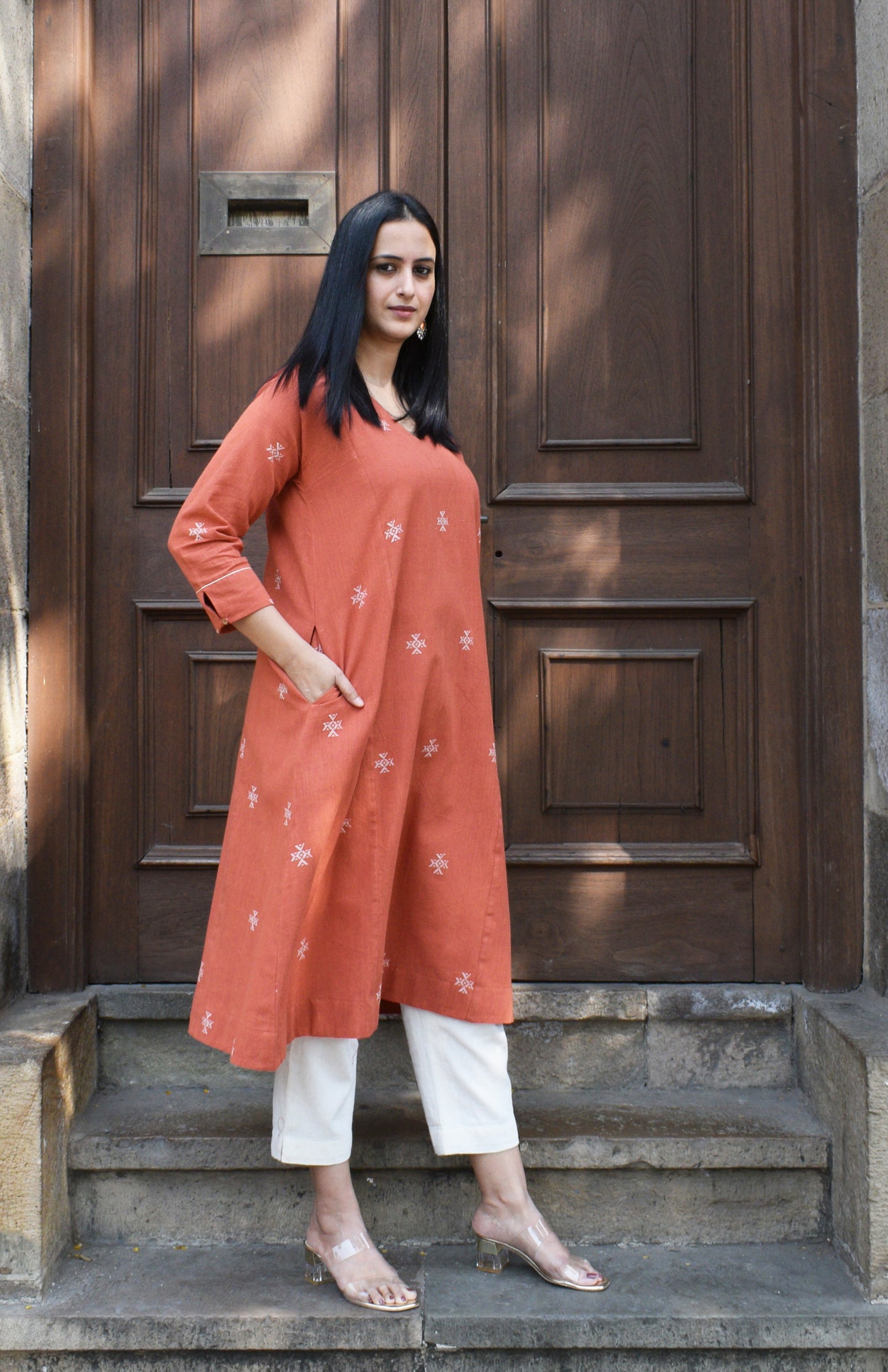 Rust orange A line kala cotton kurta with V neck and ivory trousers
